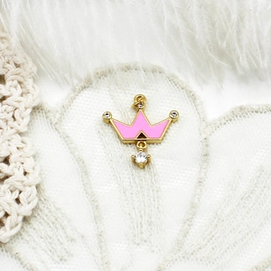 Detailed view of crown pendant with pink enamel and sparkling clear crystal accents