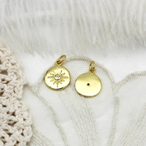 Macro shot of 18K gold plated celestial charm with sunburst pattern and tiny zircon
