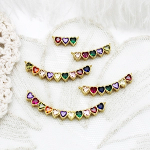 Macro detail of 18K gold plated heart connectors with colorful cubic zirconia settings