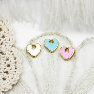 Macro detail of heart-shaped enamel charms in three colors for DIY jewelry making