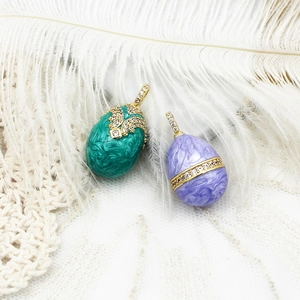 Detalle de colgantes de huevo estilo Fabergé bañados en oro de 18K con esmalte y circón