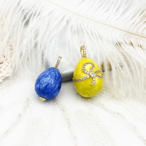 Detalle de colgantes de huevo esmaltado estilo Fabergé con mármol azul y lazo amarillo