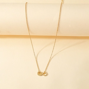 Collier élégant avec pendentif cœur infini doré présenté sur un petit socle