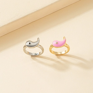 Detail of cute silver dolphin ring with texture and pink enamel fish ring with sparkling stones