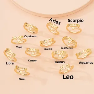 Collection of 12 zodiac gold rings with heart detail on a soft pink background