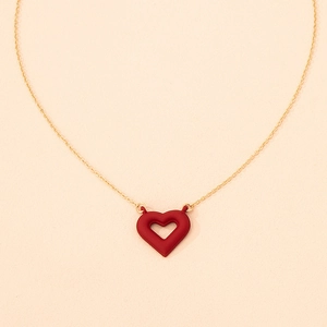 Close-up of a matte red hollow heart pendant on a delicate gold link chain