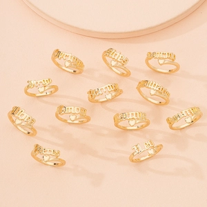 Detailed close-up of 12 zodiac gold rings featuring names like Aries and Leo with hearts