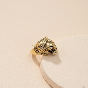 Vintage gold tiger head ring with detailed carving in a minimalist studio setting