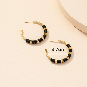 Detailed view of 3.7cm gold hoop earrings with black beads and bohemian style
