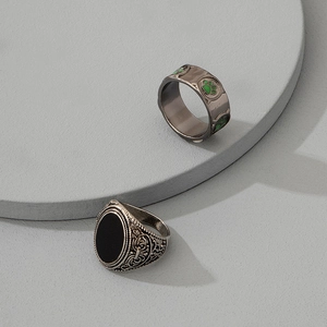 Anello con sigillo vintage con pietra nera e fascia con impronta verde su podio grigio