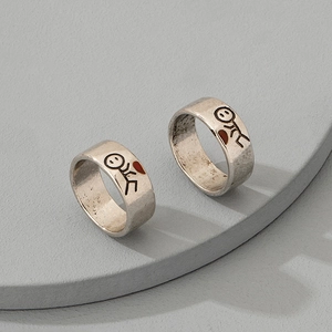 Retro silver couple rings with matchstick characters and red hearts on grey stone pedestal