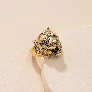 Detailed close-up of a vintage golden tiger head ring showcasing intricate facial carvings