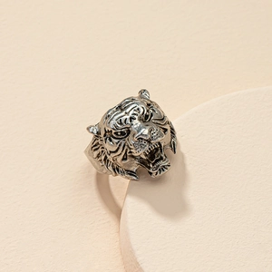 Detailed close-up of a vintage tiger head ring with intricate metal textures and carvings