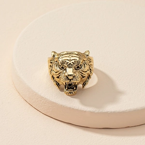 Detailed close-up of a vintage golden tiger head ring on a minimalist stone display base