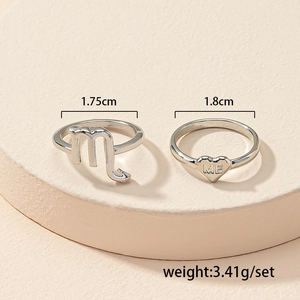 Macro shot of a two-piece silver heart ring set with Scorpio symbol and ME engraving