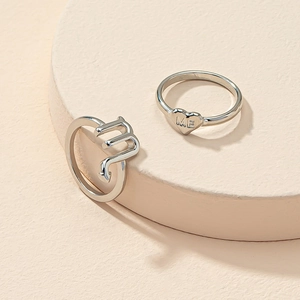 Macro shot of silver Scorpio sign and heart-shaped rings with ME engraving