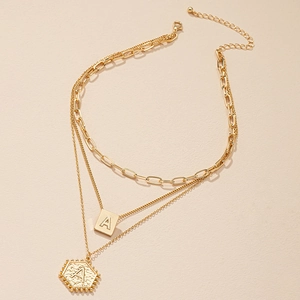 Goudkleurige meerlaagse ketting met letter A vierkante hanger en zeshoekige bedel