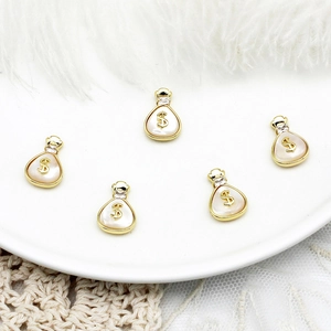 Close-up of five 18K gold-plated money bag charms with mother-of-pearl and dollar symbols
