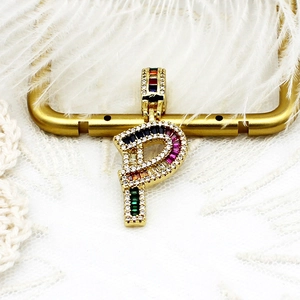 Détail du pendentif lettre P doré avec zircons multicolores et cristaux brillants