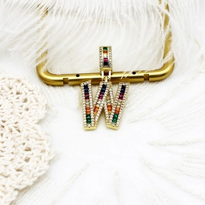 Macro d'un pendentif lettre W plaqué or 18k avec zircons colorés et diamants étincelants