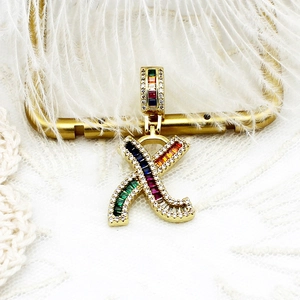 Vue macro du pendentif lettre X plaqué or 18k avec zircons colorés et pavé de diamants