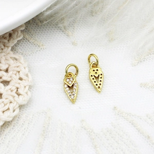 Macro shot of gold arrow pendants with micro-pave zircons for DIY jewelry assembly