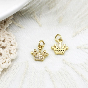 Macro shot of gold crown pendants with micro-pave zircons and textured details for DIY jewelry