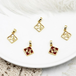 Detail van 18K vergulde Fu hangers met rood emaille en wit parelmoer op een witte schaal