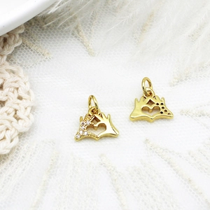 Detail of heart gesture pendants with cubic zirconia and gold finish for DIY jewelry