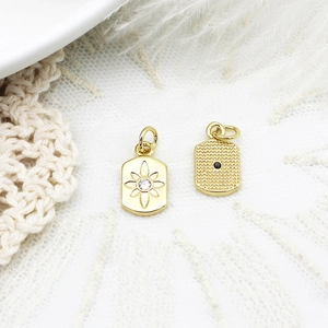 Macro view of gold pendant showing star engraving with zircon and dotted texture back