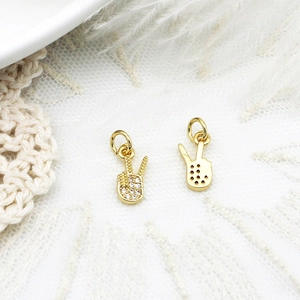 Detailed view of gold-plated V-sign charms with micro-pave zircons and honeycomb back
