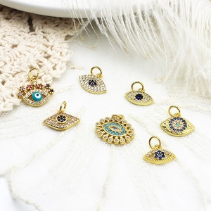 Colgantes de ojo turco bañados en oro de 18k con circonitas sobre encaje blanco