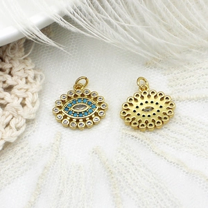 Detalle macro de colgantes de ojo turco bañados en oro 18k con turquesa y cristales