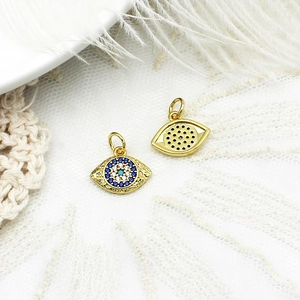 Vista macro de dijes de ojo turco bañados en oro 18k con micro-pavé de circonitas en encaje