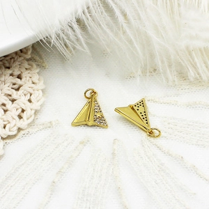 Detailed view of gold paper plane charms with micro-paved zircons and star accents
