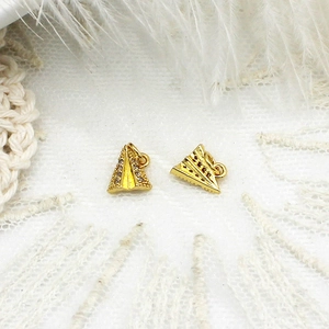 Macro detail of gold paper plane pendants with micro zircon inlay on white lace background