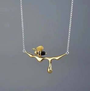 Nahaufnahme des 18K vergoldeten Bienenanhängers mit Emaille-Details an einer feinen Kette