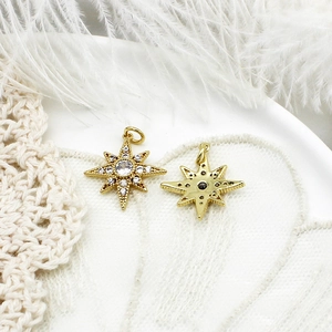 Macro shot of 18K gold star pendants with micro-pave stones and hollow back design