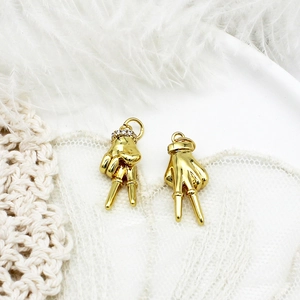 Vue détaillée de deux breloques main en forme de V doré pour accessoires de bijoux DIY.