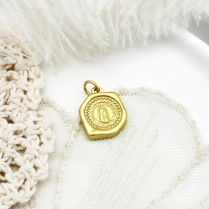 Macro shot of vintage matte gold Virgin Mary pendant with detailed religious relief