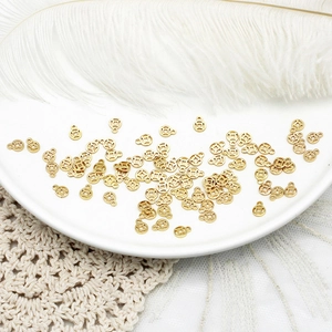 Macro view of gold lucky coin charms for DIY jewelry on white ceramic plate