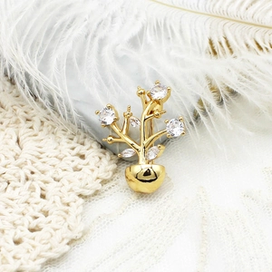 Goldene Weihnachtsbaum-Brosche mit Mikro-Zirkonia auf einem eleganten Spitzenhintergrund