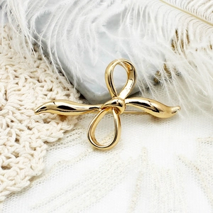 Elegant gold bow brooch with a polished mirror finish for women's luxury coats