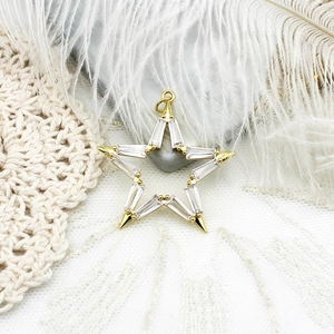 Macro view of 18K gold plated hollow star pendant with inlaid cubic zirconia and tapered ends