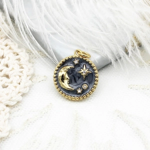 Detail view of 18K gold plated celestial pendant with moon, star and black enamel