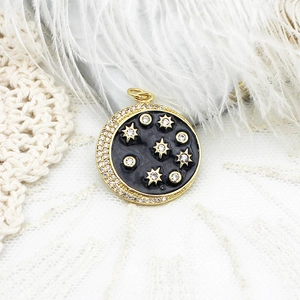 Detailed close-up of 18K gold plated celestial charm with black enamel and zircons
