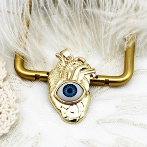 Detailed macro view of 18K gold plated anatomical heart pendant with blue evil eye stone