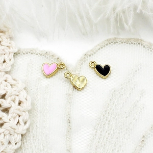 Detail of pink and black heart charms with 18K gold plating for DIY jewelry making