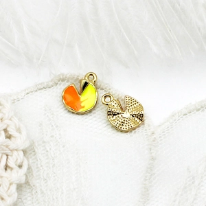 Detailed close-up of geometric 18K gold-plated fruit charms with enamel and embossed finish