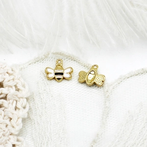 Macro view of 18K gold plated bee pendants with enamel inlay for DIY jewelry